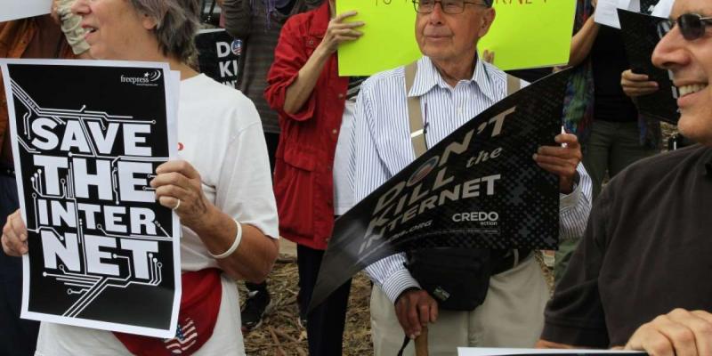 Woman holding Save Our Internet sign